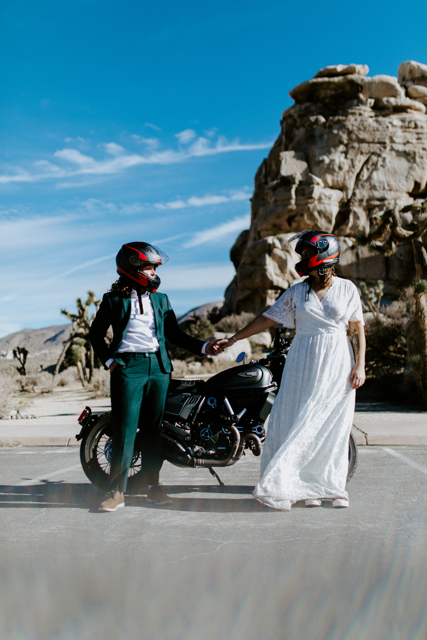 Madison and Becca stand with their motorcycle at Joshua Tree National Park.