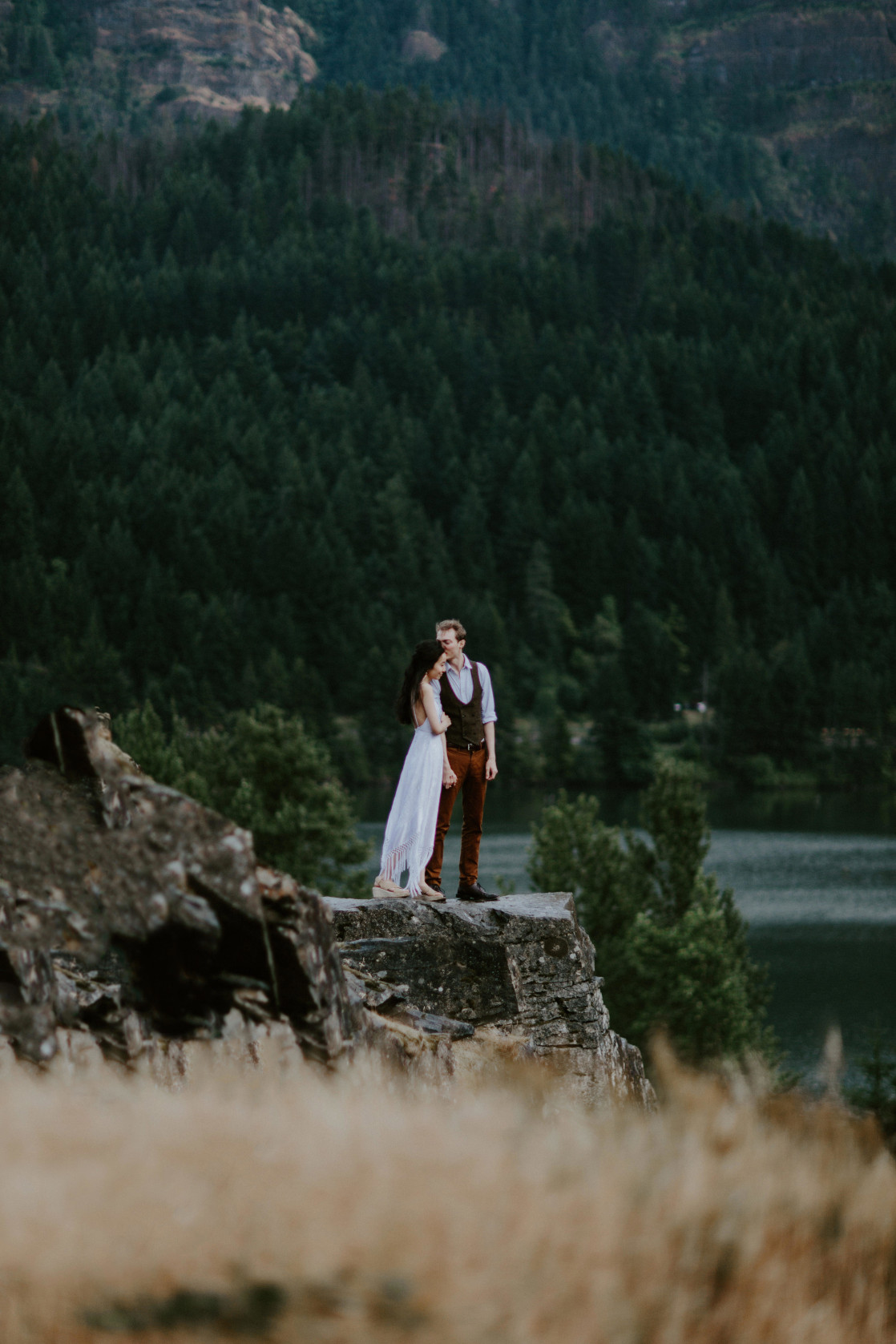 Kimberlie and Jacob stand on the top of a cliff rock at Cascade Locks in Oregon. Elopement wedding photography at Cascade Locks by Sienna Plus Josh.