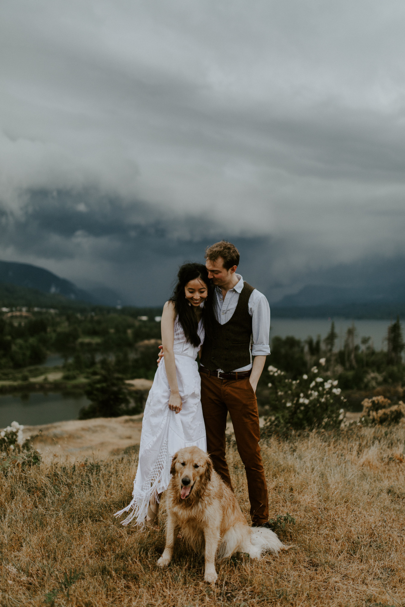 Jacob holds Kimberlie while Cody sits at their feet. Elopement wedding photography at Cascade Locks by Sienna Plus Josh.