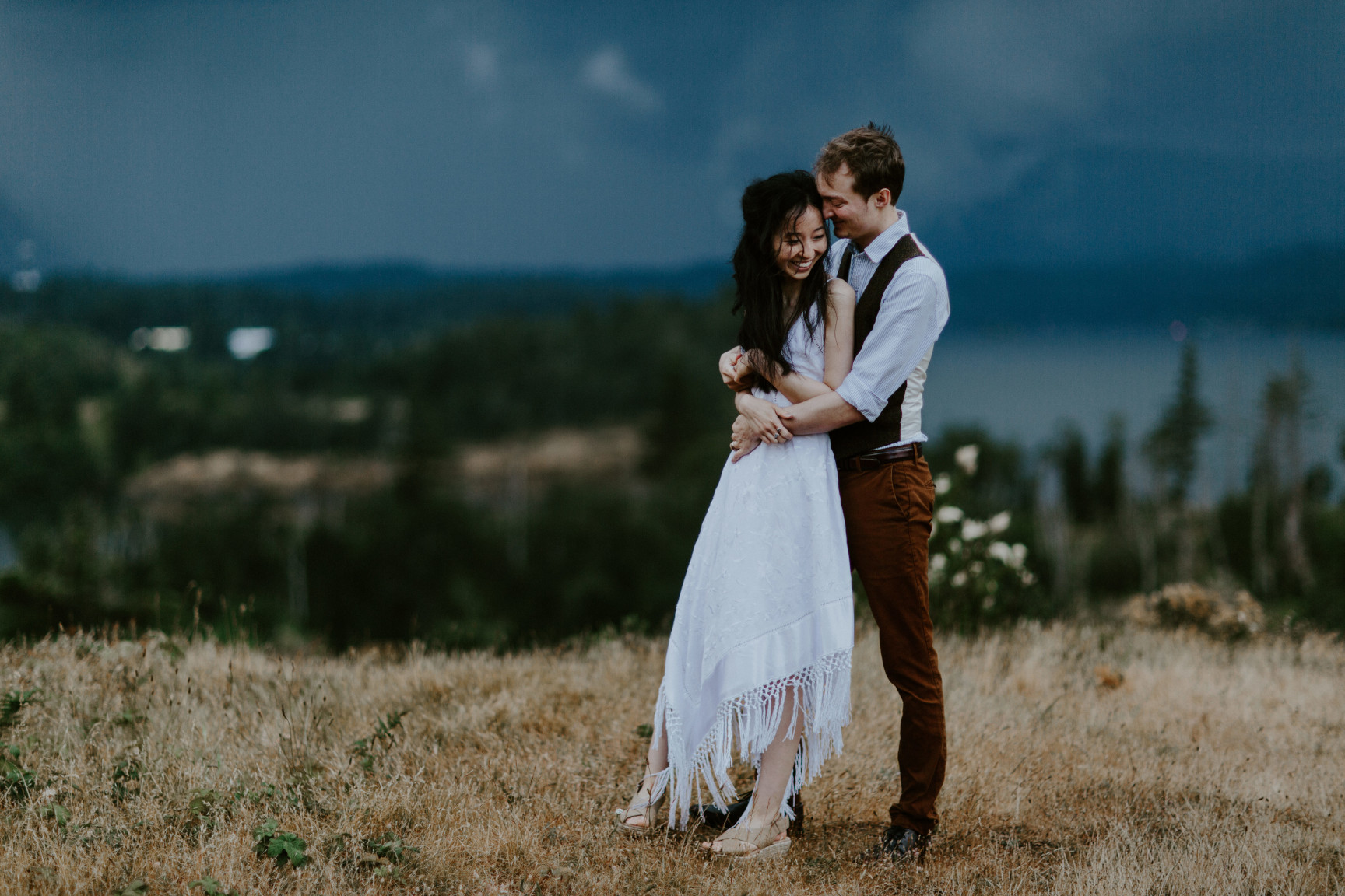 Jacob holds Kimberlie as they stand before the storm headed toward Cascade Locks, OR. Elopement wedding photography at Cascade Locks by Sienna Plus Josh.