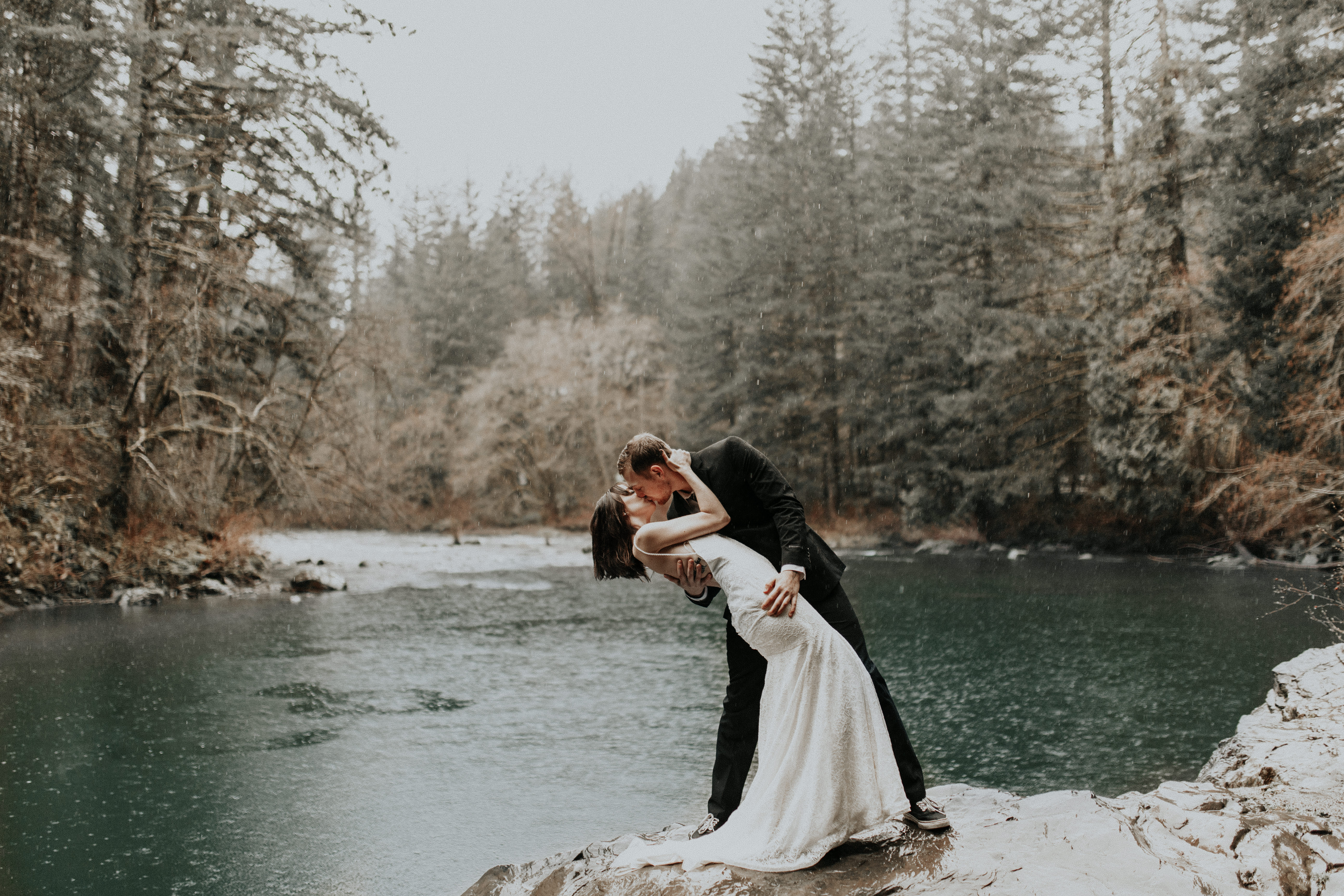 TJ dips Paige along the riverside of Moulton Falls during their elopement wedding in Washington.