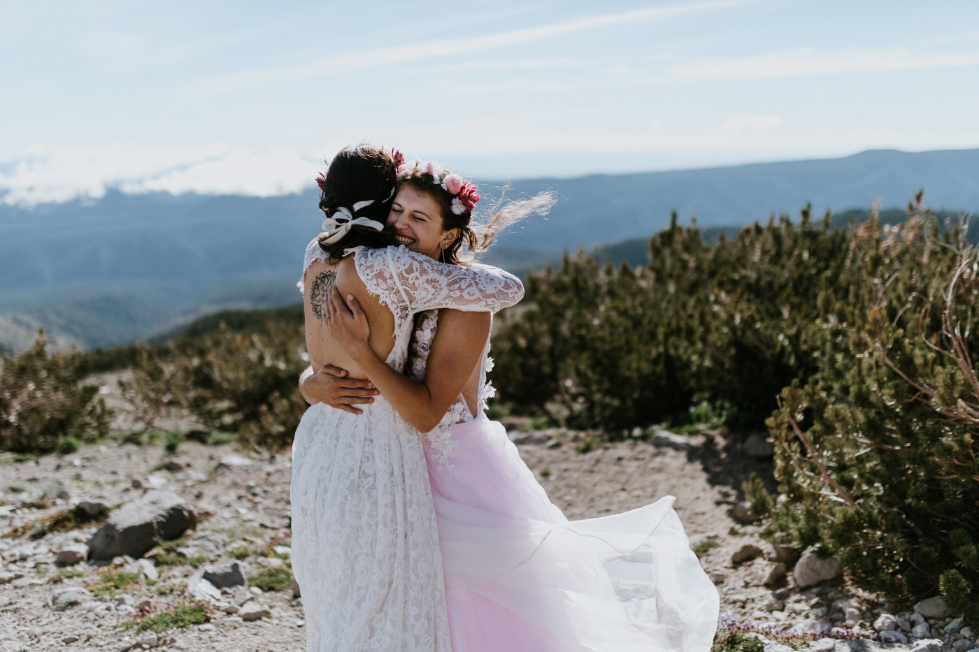 Heather and Margaux hugging with a view of the woods in the background. Elopement photography at Mount Hood by Sienna Plus Josh.