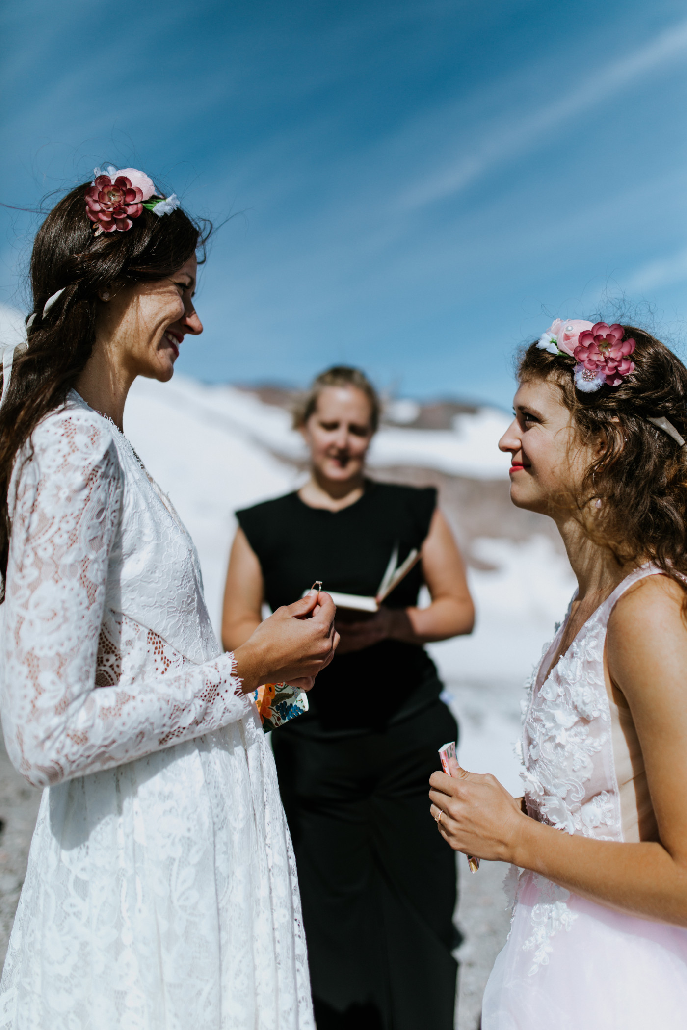 Heather and Margaux stand face to face as Margaux holds Heather's ring. Elopement photography at Mount Hood by Sienna Plus Josh.