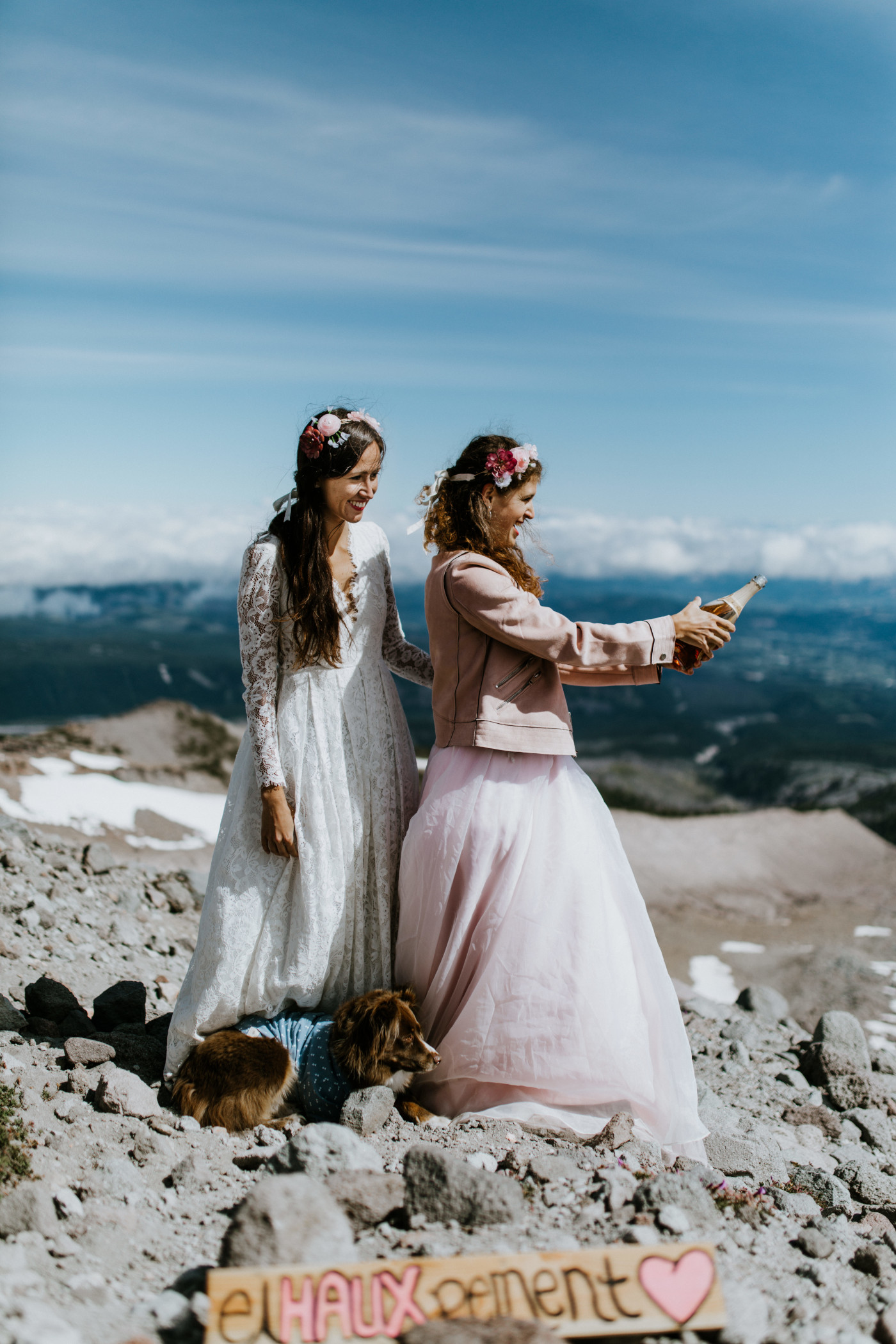 Margaux and Heather pop a bottle of champagne on top of Mount Hood. Elopement photography at Mount Hood by Sienna Plus Josh.