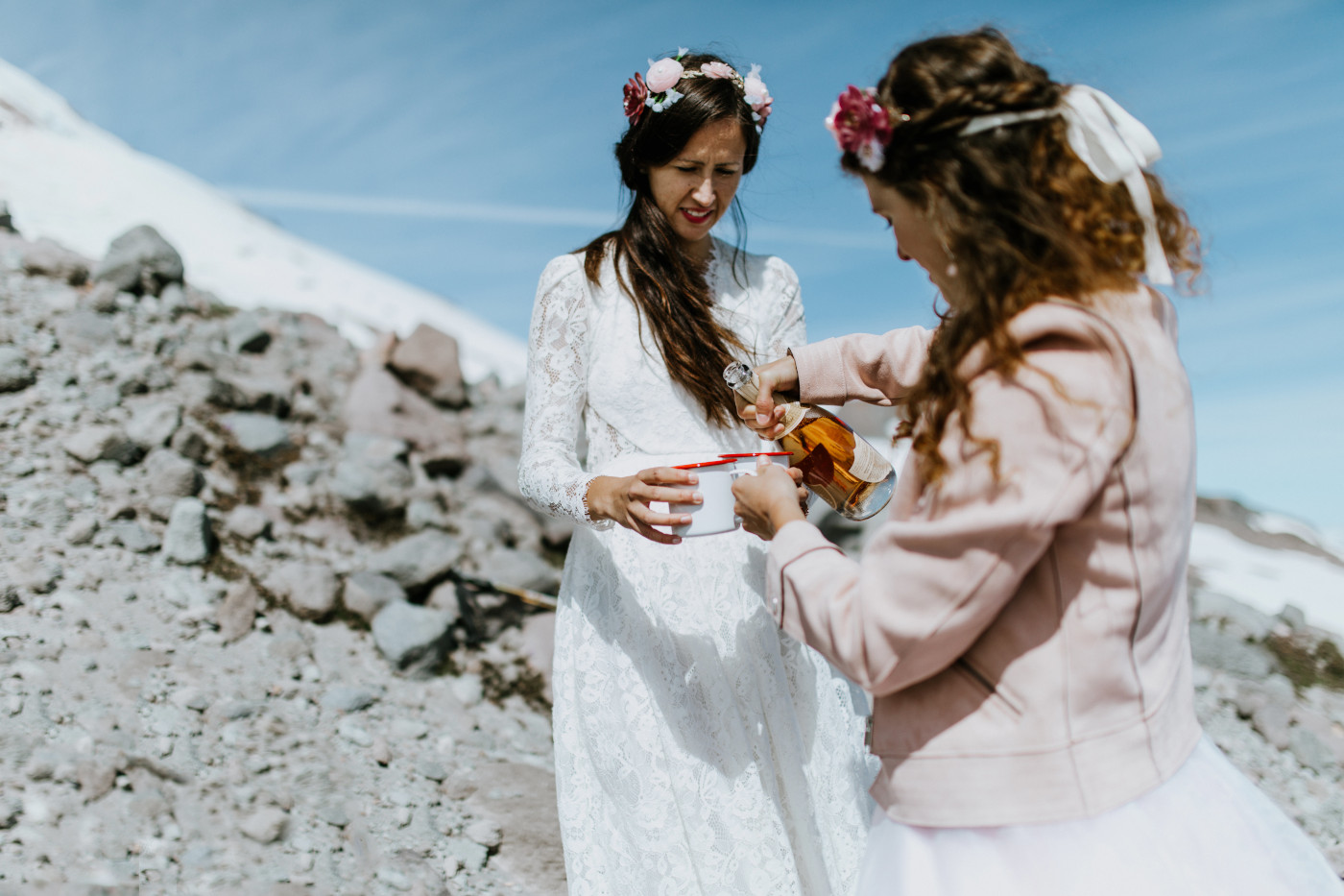 Margaux and Heather pour champagne into camping mugs. Elopement photography at Mount Hood by Sienna Plus Josh.