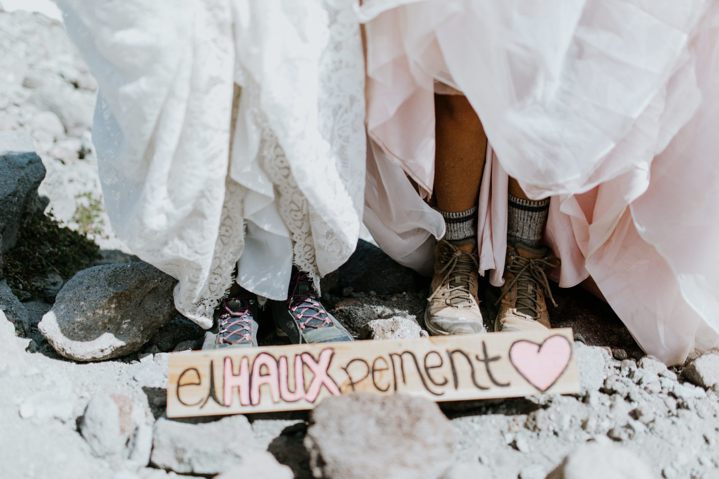Margaux and Heather show their hiking shoes with their hand made sign. Elopement photography at Mount Hood by Sienna Plus Josh.