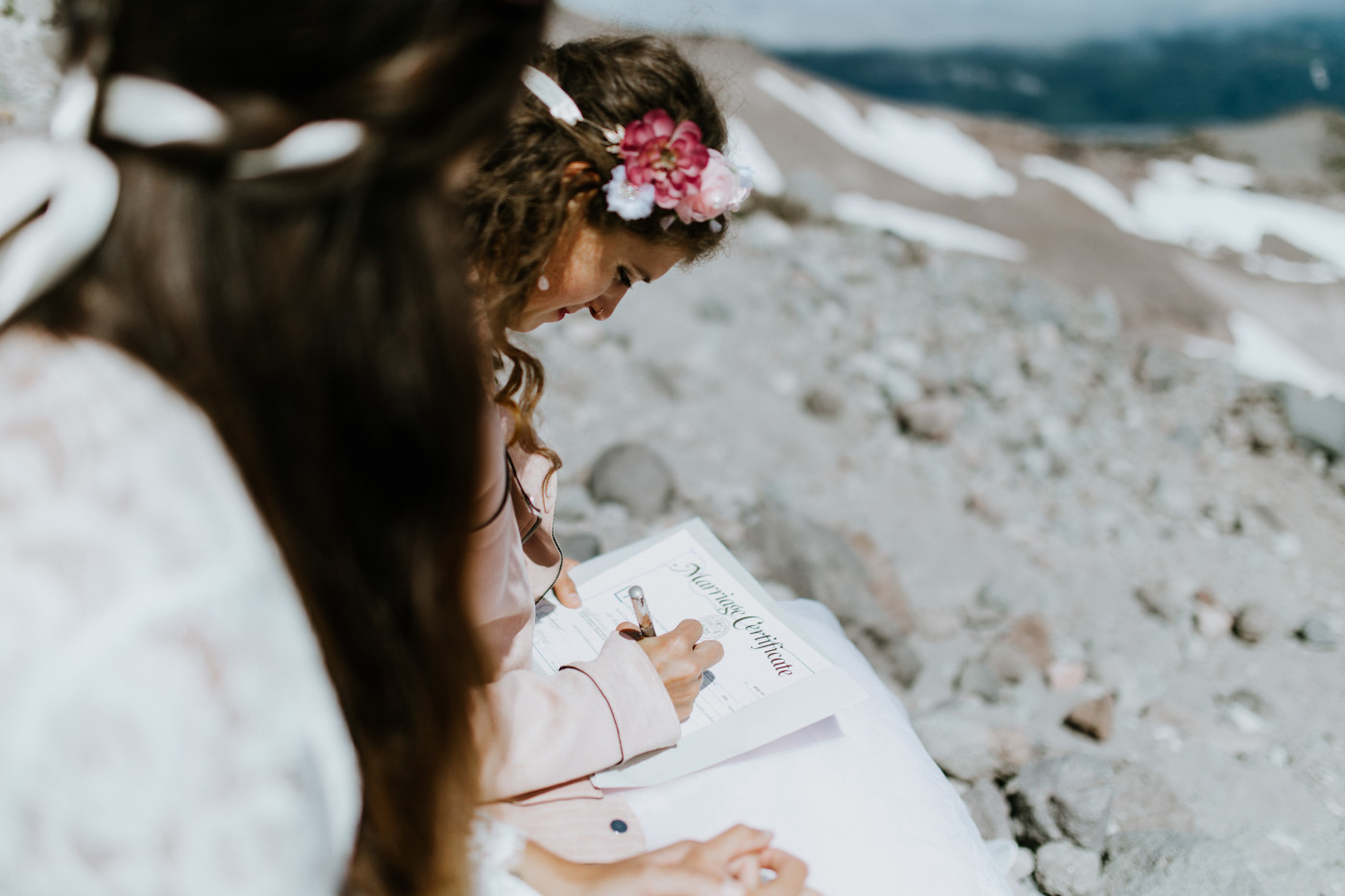 Margaux and Heather sign their marriage certificate. Elopement photography at Mount Hood by Sienna Plus Josh.