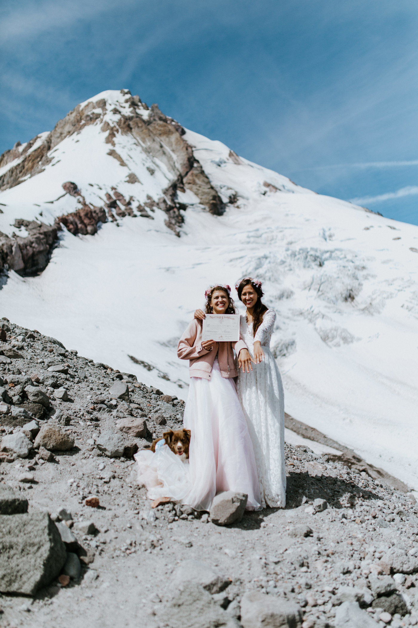 Margaux and Heather hold their marriage certificate and show off their rings in front of Mount Hood. Elopement photography at Mount Hood by Sienna Plus Josh.