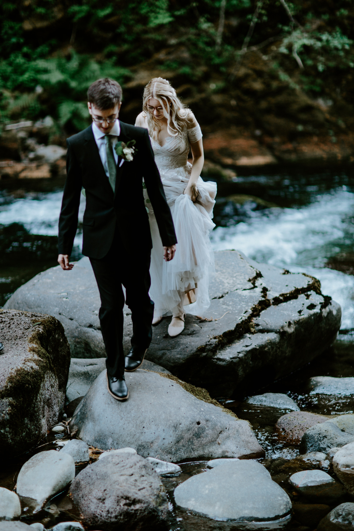 Kylie and Corey walk back across the rocks in the stream in Mount Hood National Forest.