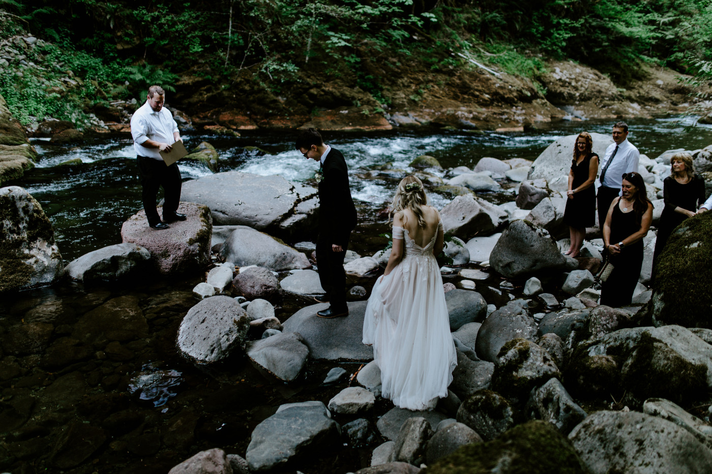 Corey and Kylie walk across the river running through Mount Hood National Foreset to their elopement spot.