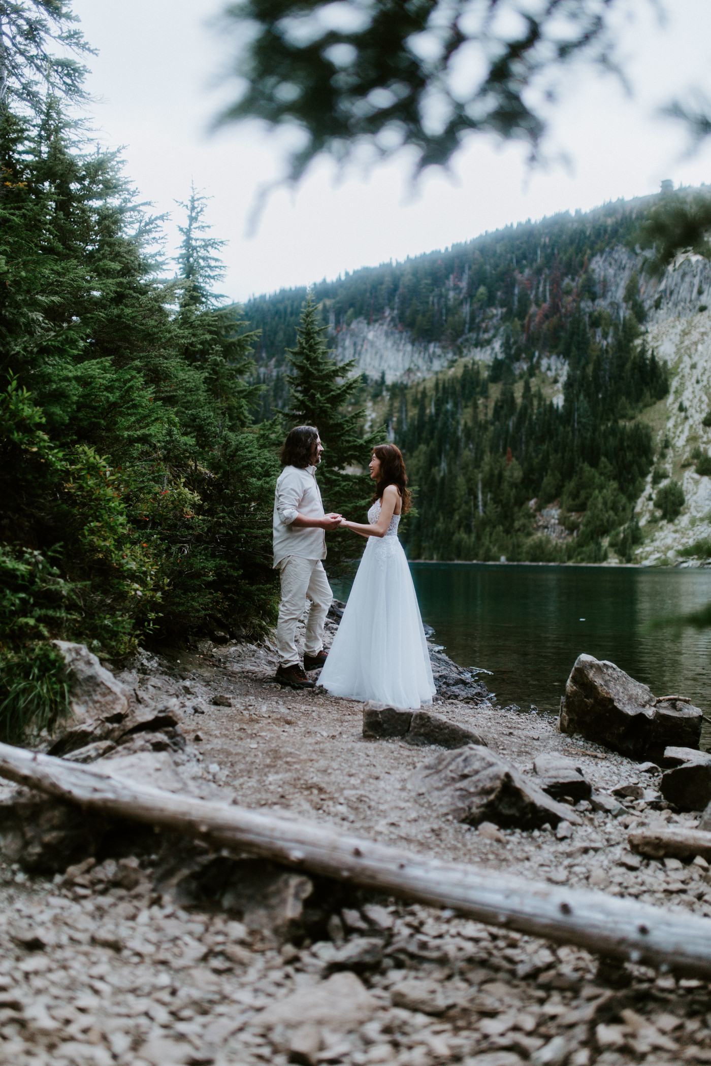 Matthew and Katrina stand hand in hand near a lake at Mount Rainier for their elopement.