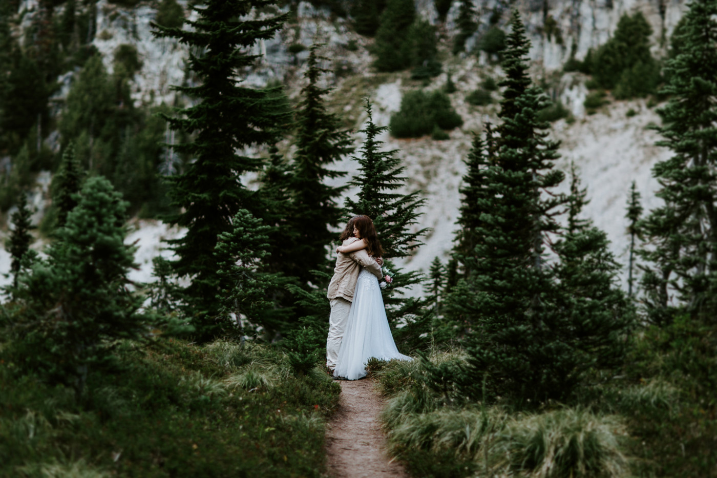 Matthew and Katrina hug on a path in Mount Rainier during their elopement.