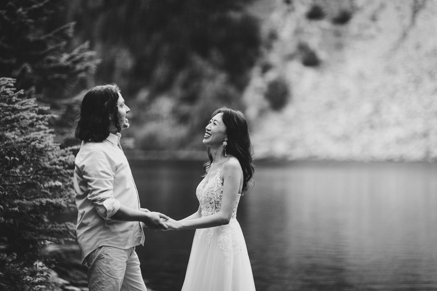 Katrina and Matthew stand hand in hand near a lake at Mount Rainier for their elopement.