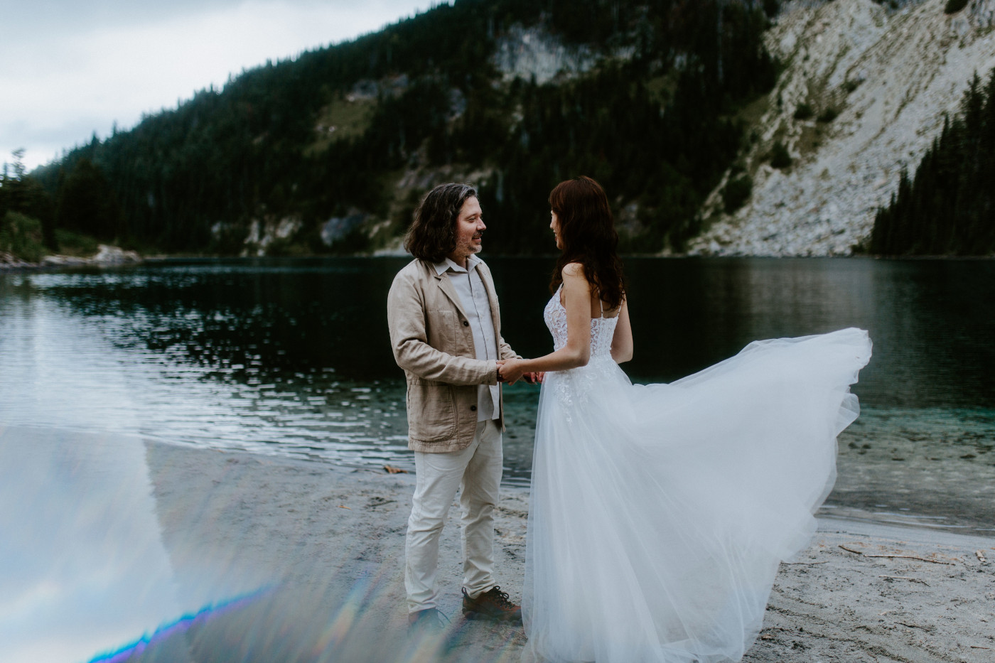 Matthew and Katrina stand hand in hand near a lake at Mount Rainier for their elopement.