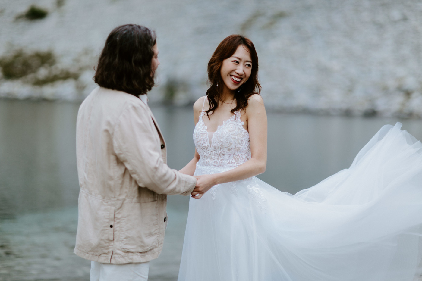 Katrina and Matthew stand hand in hand near a lake at Mount Rainier for their elopement.