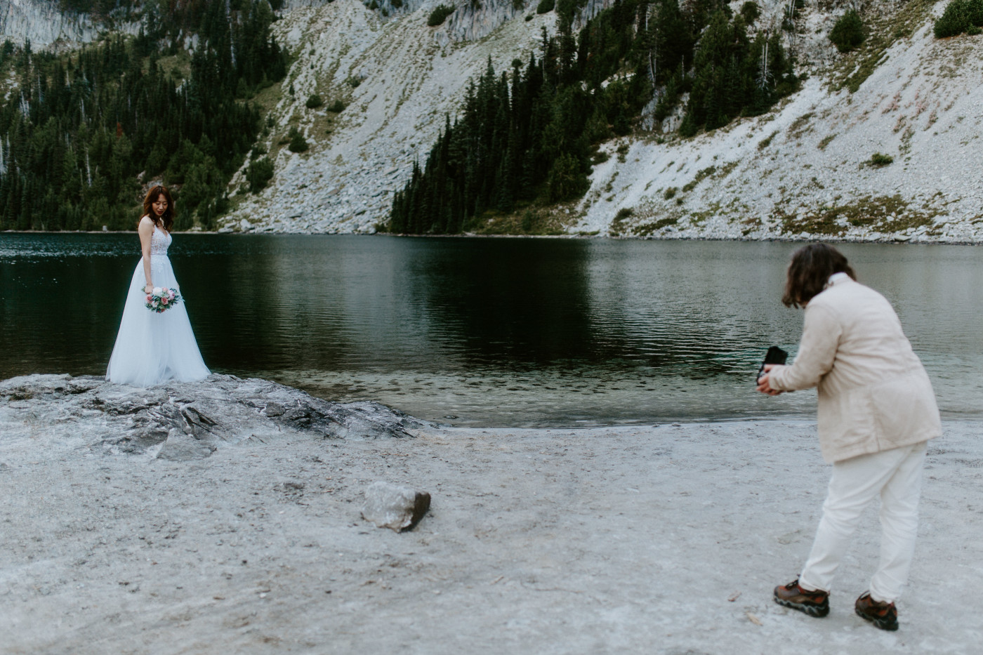 Matthew takes photos of Katrina with his film camera a lake at Mount Rainier for their elopement.