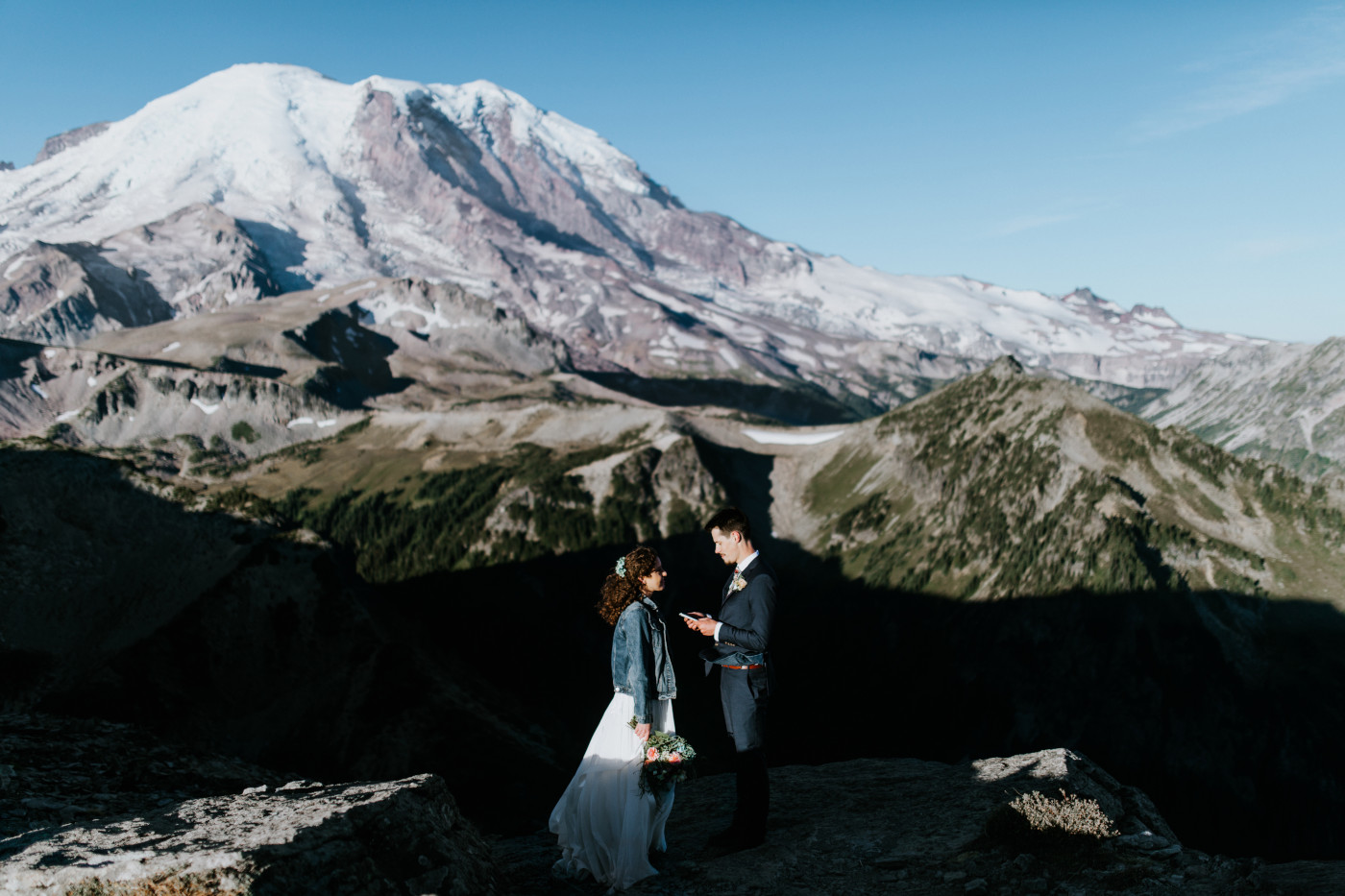 Chad and Tasha during their elopement with a view of the waterfall in the background. Elopement photography at Mount Rainier by Sienna Plus Josh.