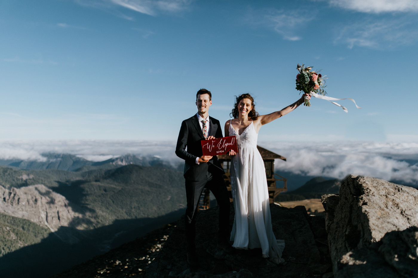 Tasha and Chad hold their elopement sign. Elopement photography at Mount Rainier by Sienna Plus Josh.