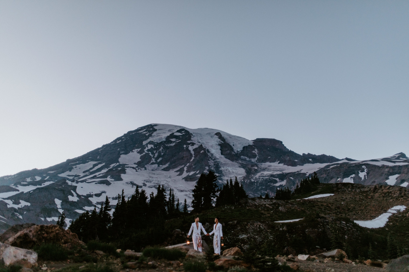 Fred and Brooks walk with lanterns in Mount Rainier after their elopement ceremony.
