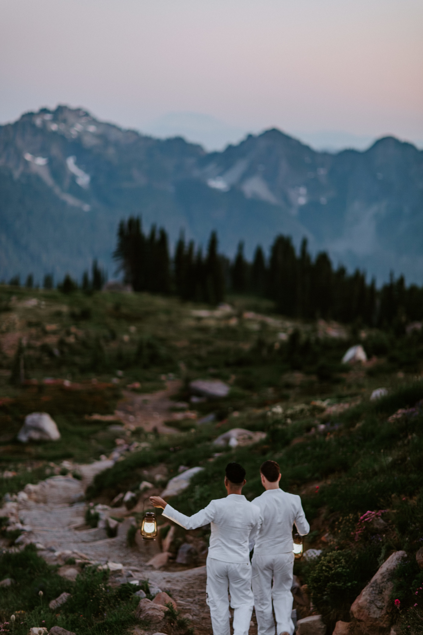 Brooks and Fred walk down a trail with lanterns in Mount Rainier, Washington.