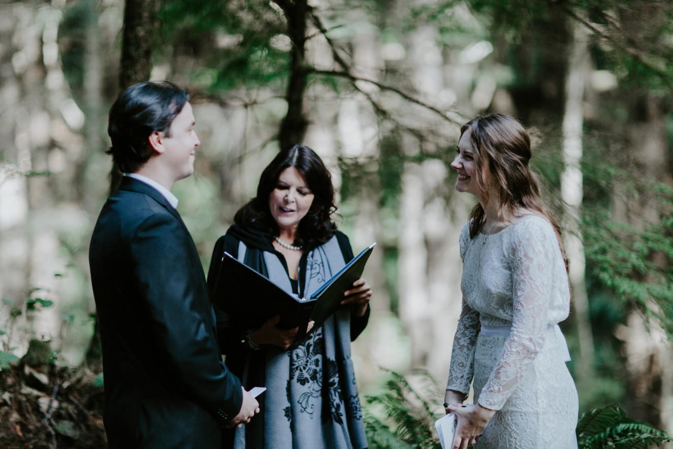 Nicole and Vlad stand in front of each other at their wedding ceremony at Cannon Beach. Elopement wedding photography at Cannon Beach by Sienna Plus Josh.