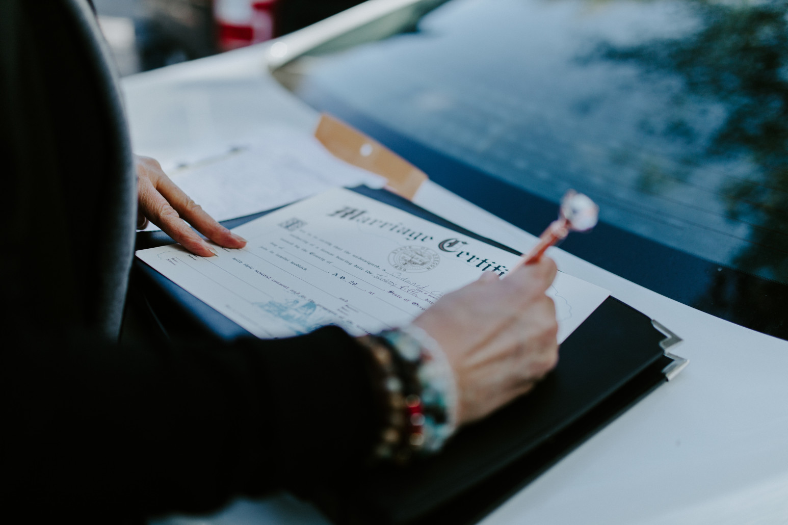 Nicole and Vlad sign their marriage certificate. Elopement wedding photography at Cannon Beach by Sienna Plus Josh.