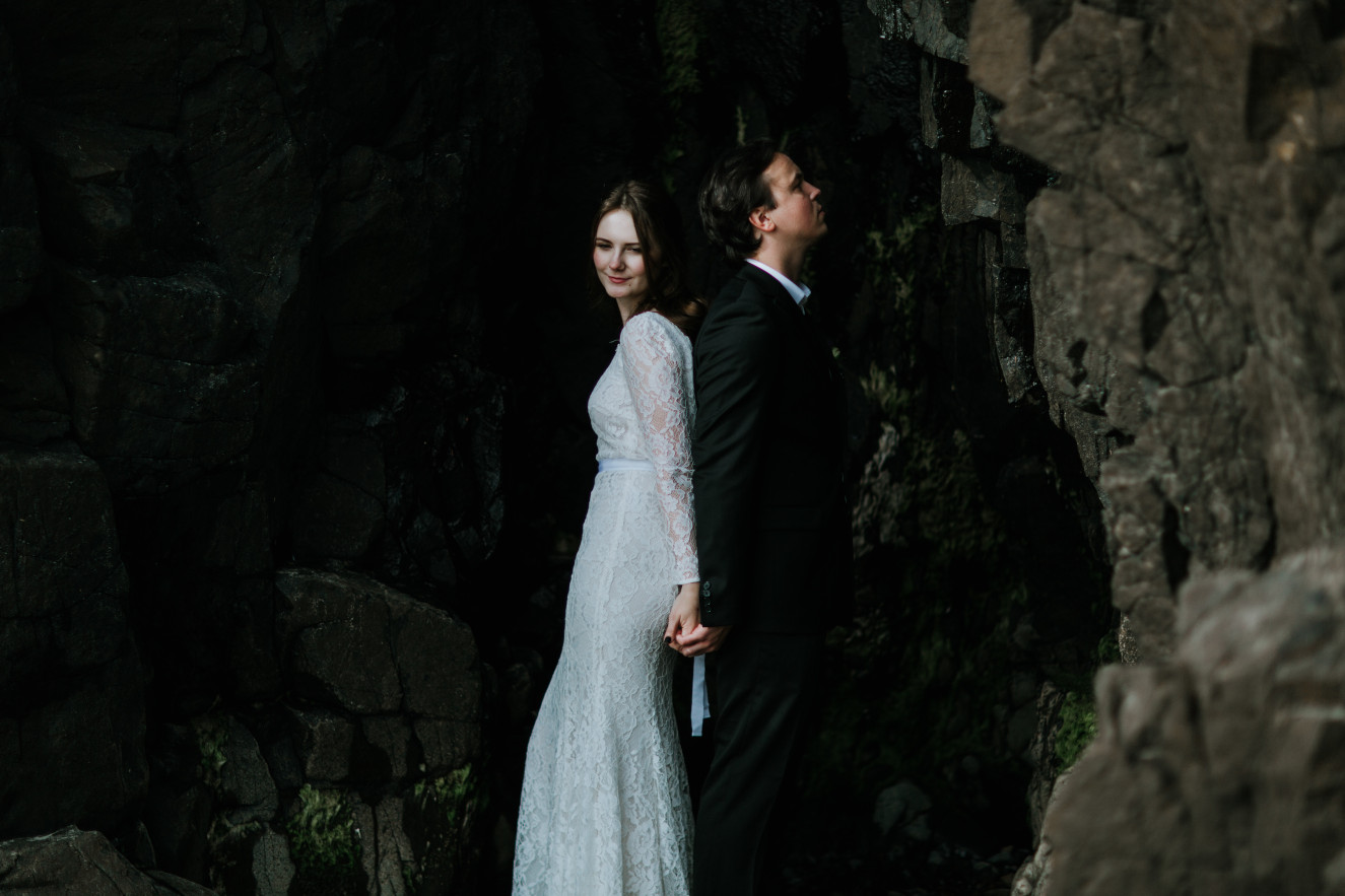 Nicole and Vlad stand in front of a cliff. Elopement wedding photography at Cannon Beach by Sienna Plus Josh.