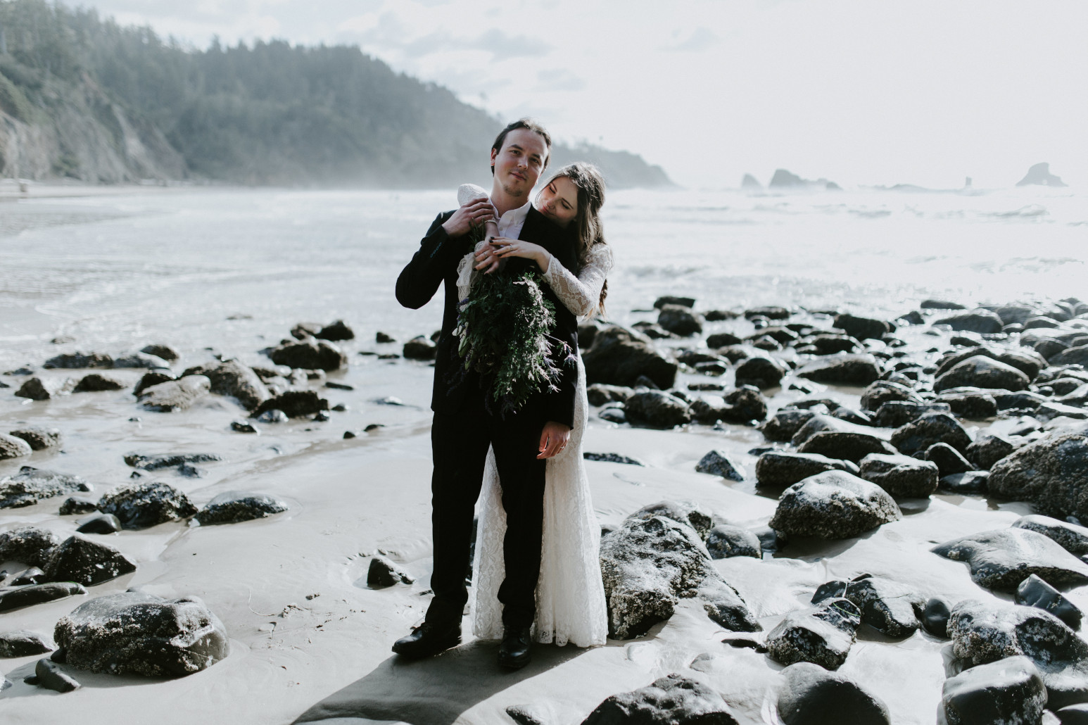 Nicole and Vlad stand near the ocean at Indian Beach. Elopement wedding photography at Cannon Beach by Sienna Plus Josh.