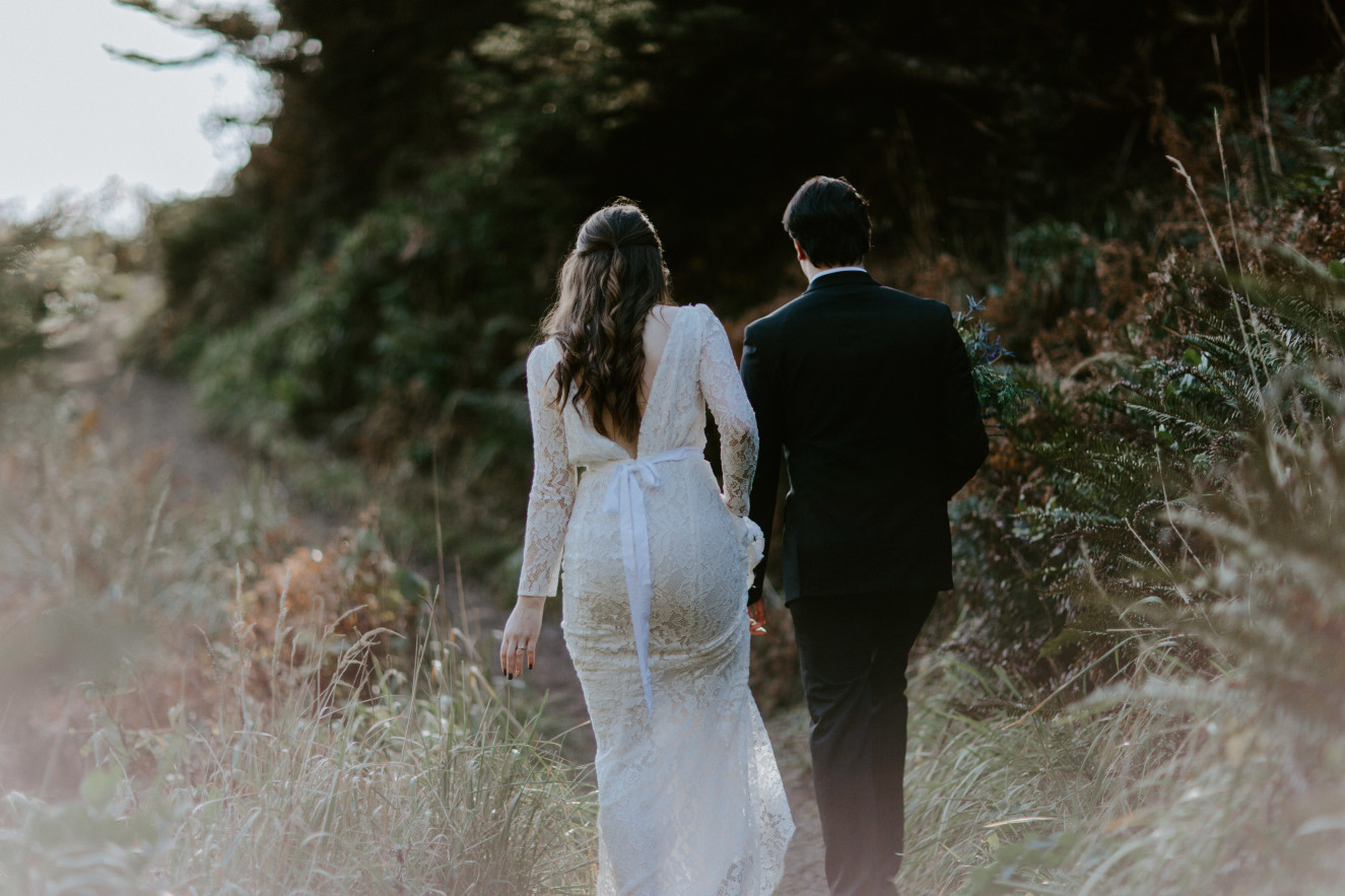 Nicole and Vlad walk next to a cliff. Elopement wedding photography at Cannon Beach by Sienna Plus Josh.