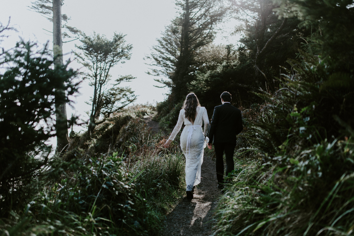 Nicole and Vlad walk up to a cliff line. Elopement wedding photography at Cannon Beach by Sienna Plus Josh.