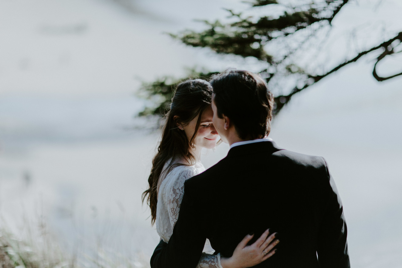 Nicole and Vlad kiss near a cliff. Elopement wedding photography at Cannon Beach by Sienna Plus Josh.