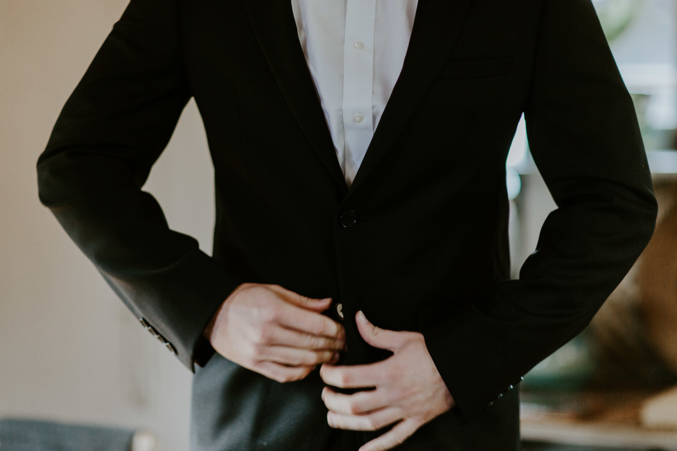 Vlad buttons up his jacket at Cannon Beach. Elopement wedding photography at Cannon Beach by Sienna Plus Josh.