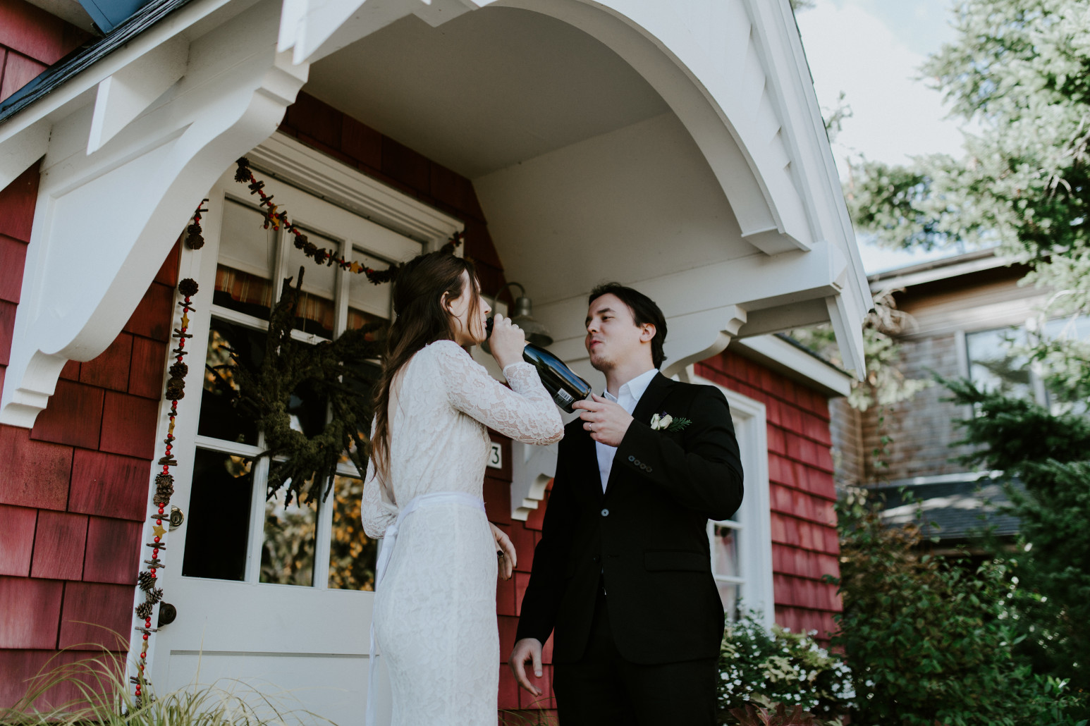 Nicole drinks from the bottle of champange. Elopement wedding photography at Cannon Beach by Sienna Plus Josh.