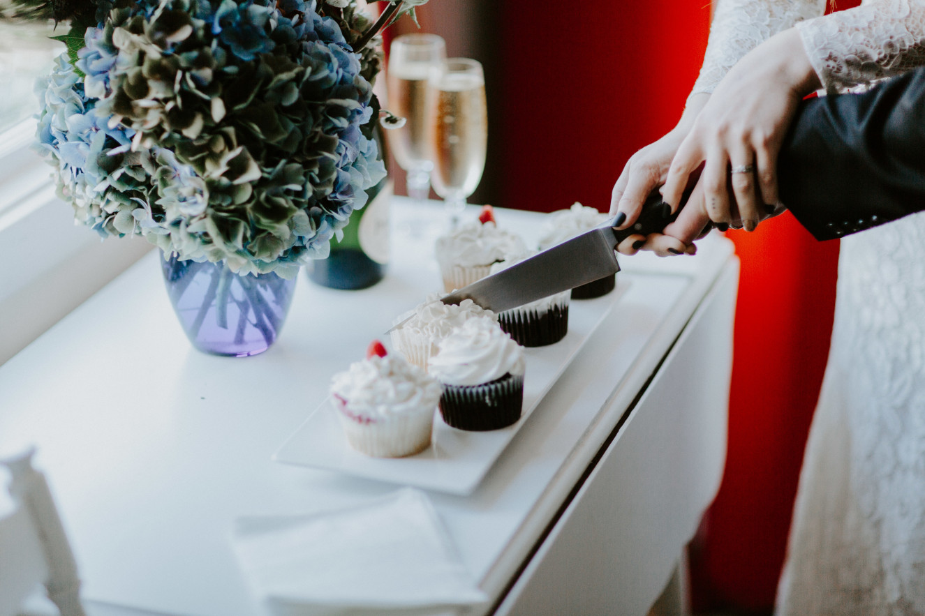 Nicole and Vlad cut into their cupcakes. Elopement wedding photography at Cannon Beach by Sienna Plus Josh.
