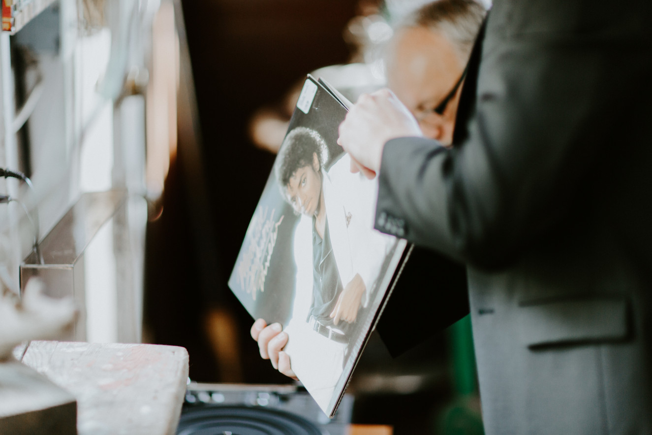 Vlad holds a vinyl of Michael Jackson at Cannon Beach. Elopement wedding photography at Cannon Beach by Sienna Plus Josh.