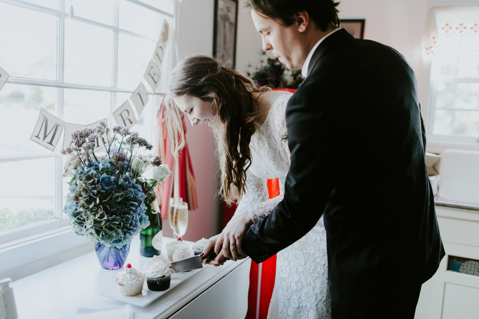 Nicole and Vlad cut their wedding cupcakes. Elopement wedding photography at Cannon Beach by Sienna Plus Josh.