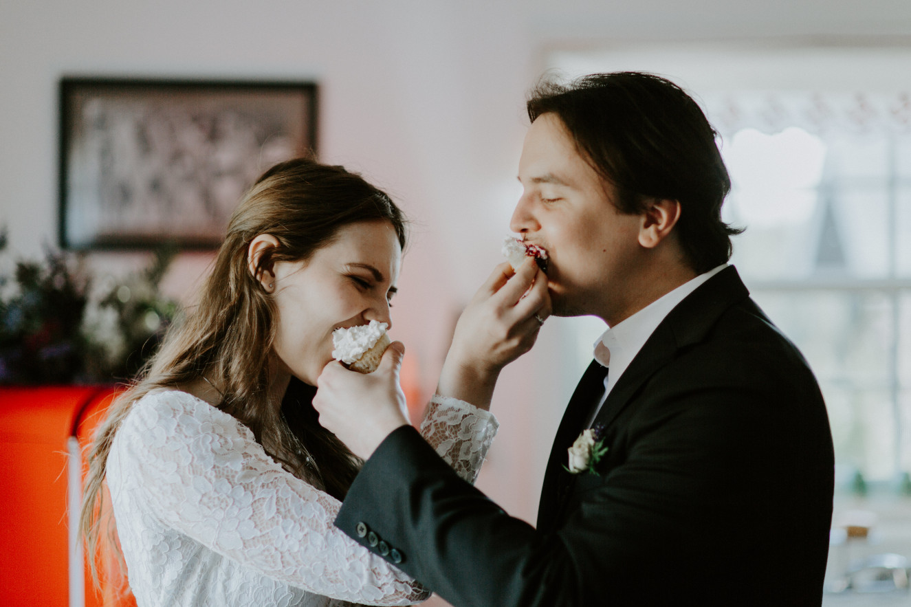 Nicole and Vlad feed each other their cupcakes. Elopement wedding photography at Cannon Beach by Sienna Plus Josh.