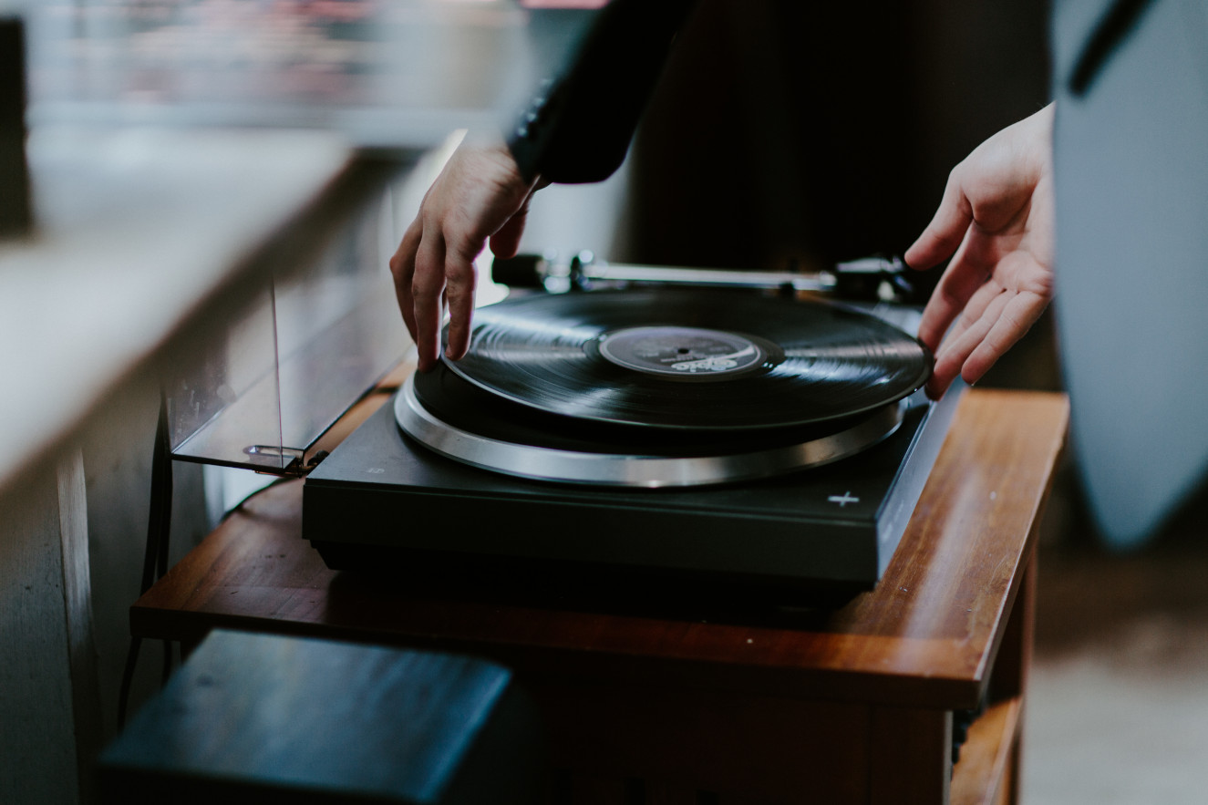 Vlad puts on a vinyl record at Cannon Beach in Oregon. Elopement wedding photography at Cannon Beach by Sienna Plus Josh.
