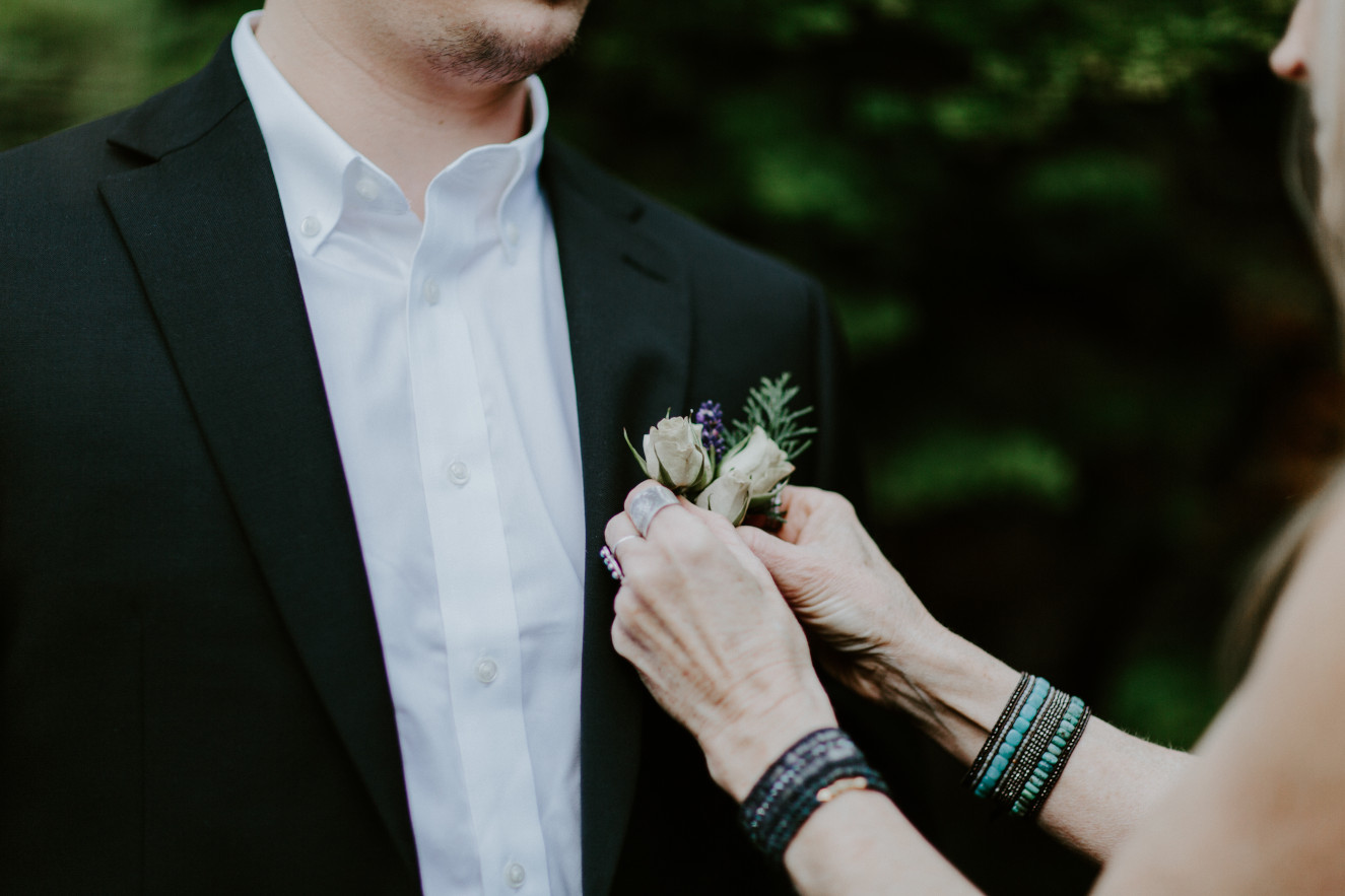 Vlad has flowers pinned to his jacket. Elopement wedding photography at Cannon Beach by Sienna Plus Josh.