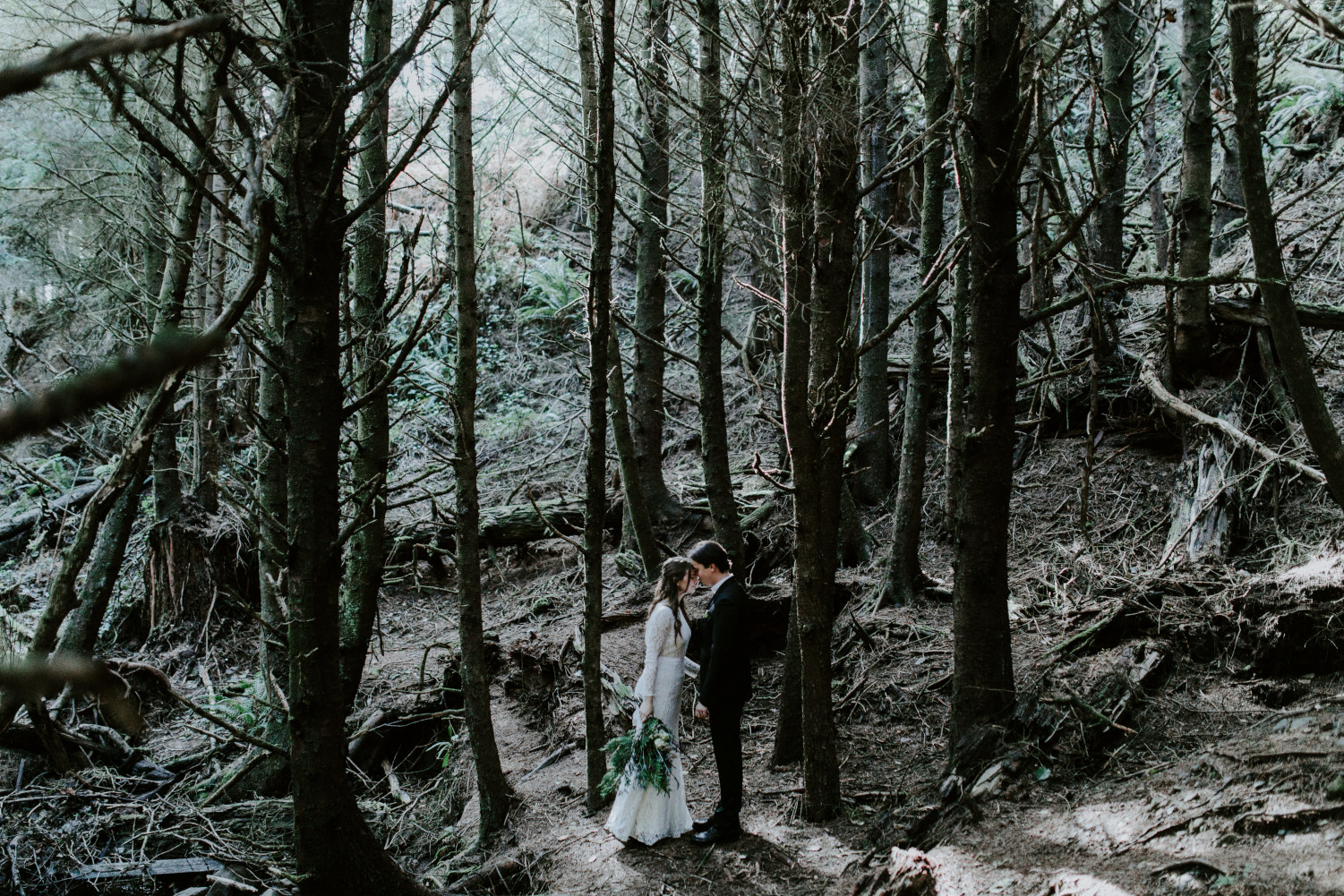 Nicole rests her head on Vlad in the forest near Cannon Beach. Elopement wedding photography at Cannon Beach by Sienna Plus Josh.