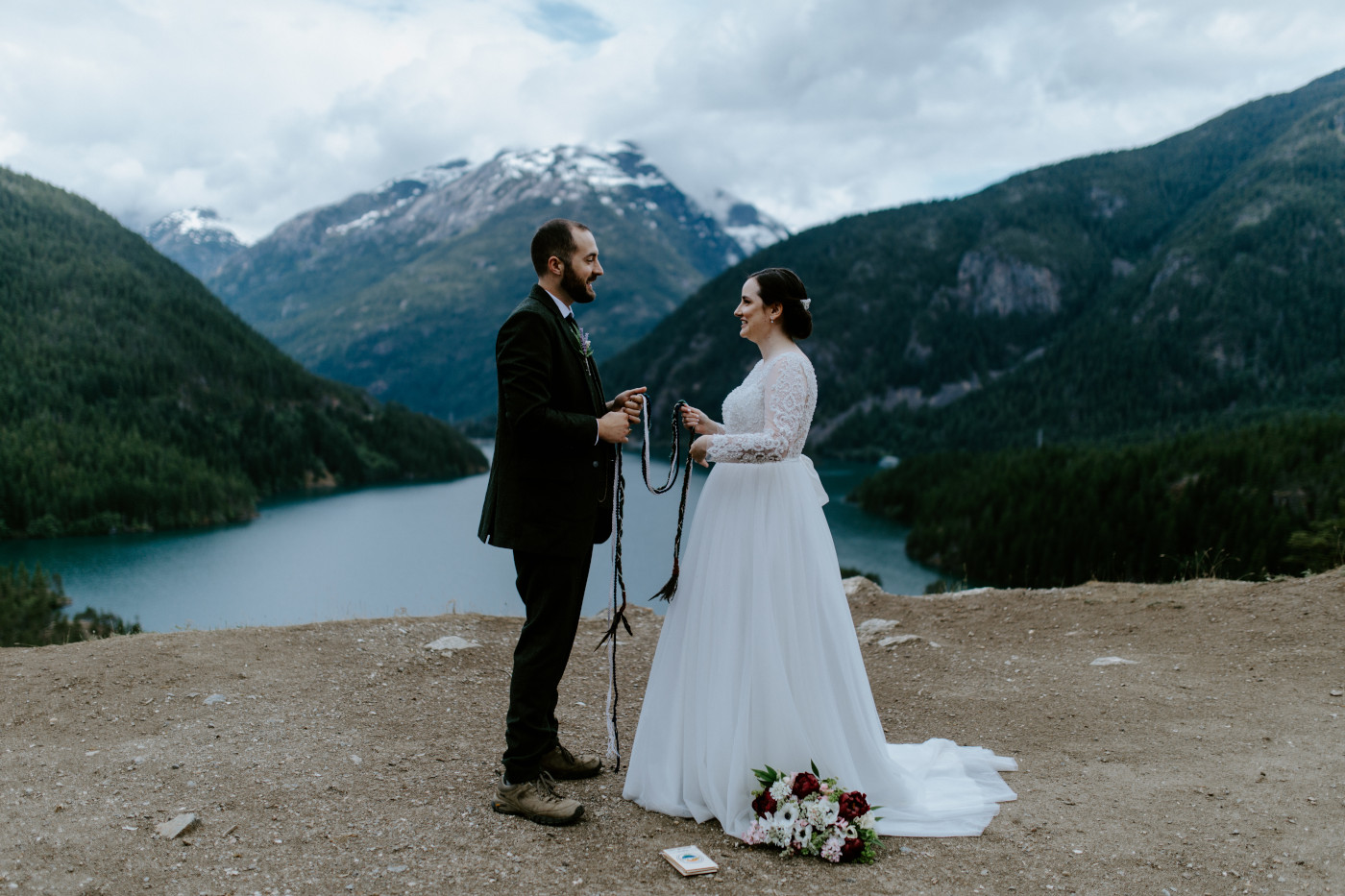 Elizabeth and Alex standing at Diablo Lake Overlook to begin the hand fastening. Elopement photography at North Cascades National Park by Sienna Plus Josh.