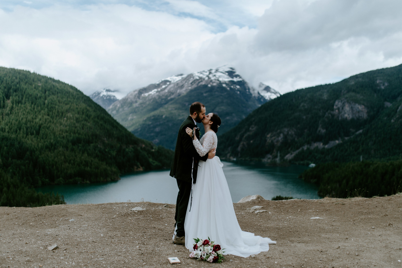 Elizabeth and Alex kiss with a view of Diablo Lake Overlook. Elopement photography at North Cascades National Park by Sienna Plus Josh.