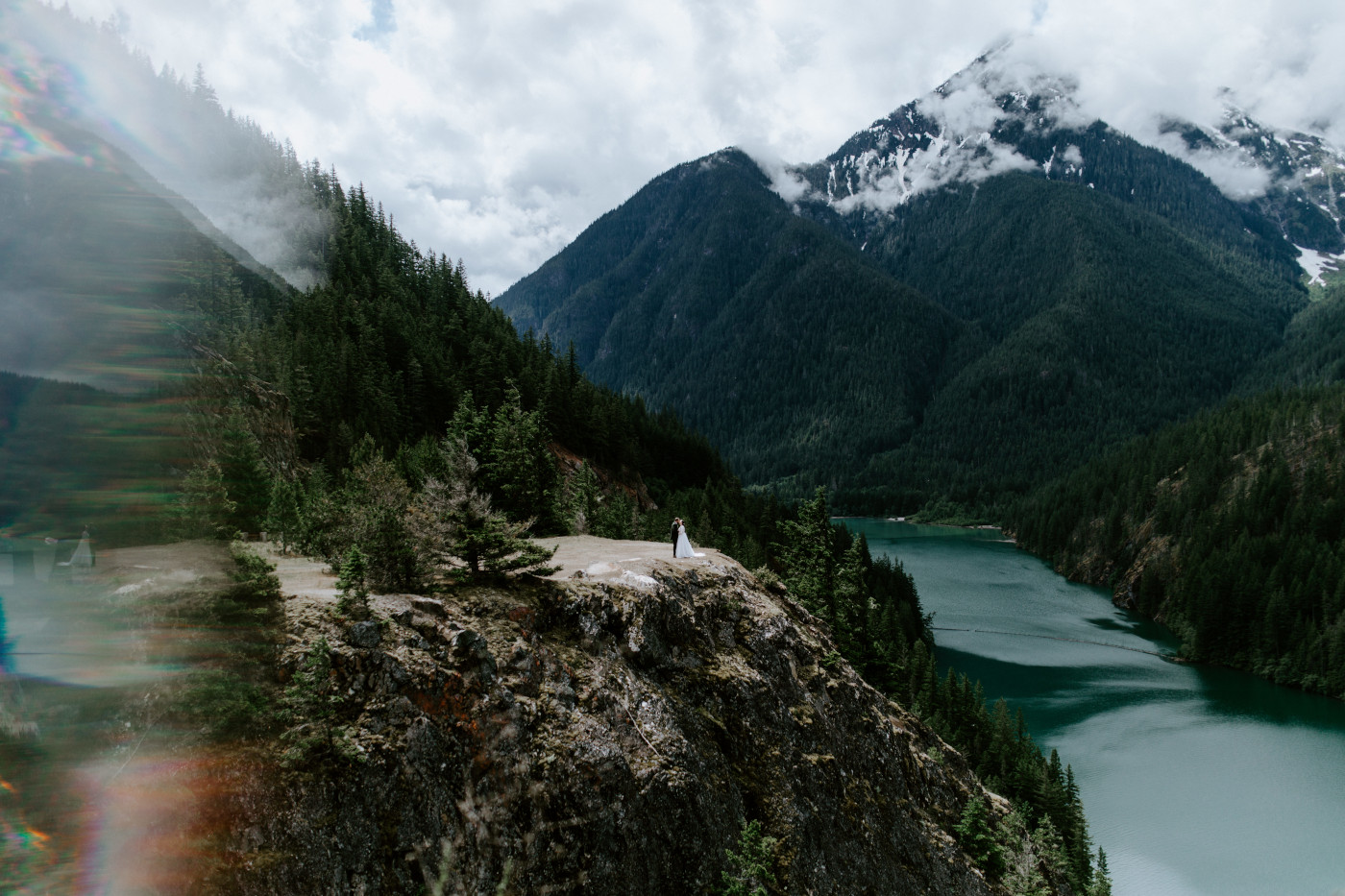 Elizabeth and Alex stand on the cliffside. Elopement photography at North Cascades National Park by Sienna Plus Josh.