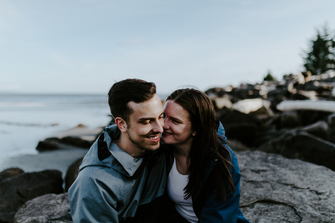 Kyle and Taylor sit close to each other on the beach. Elopement photography at North Cascades National Park by Sienna Plus Josh.