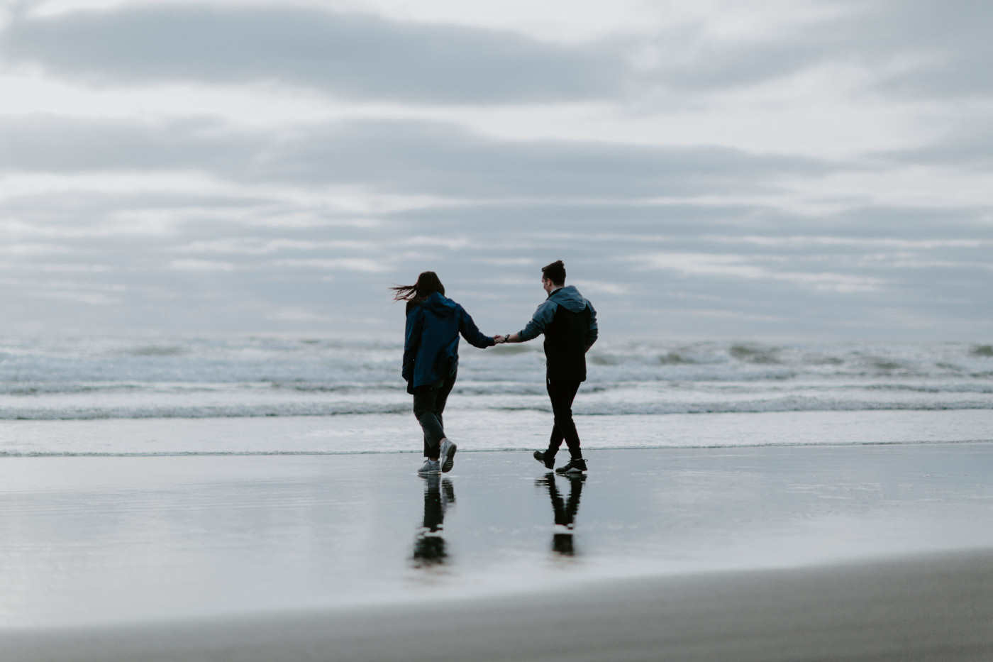 Taylor and Kyle walk along the beach near the water. Elopement photography at North Cascades National Park by Sienna Plus Josh.