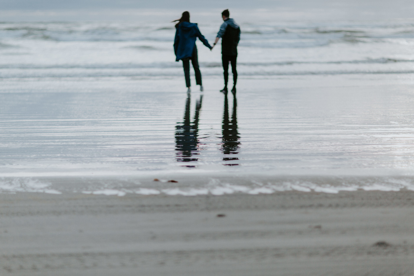 A reflection of Taylor and Kyle standing by the ocean. Elopement photography at North Cascades National Park by Sienna Plus Josh.