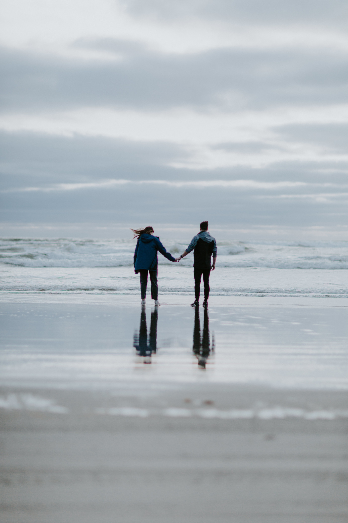 Taylor and Kyle hold hands in front of the ocean. Elopement photography at North Cascades National Park by Sienna Plus Josh.