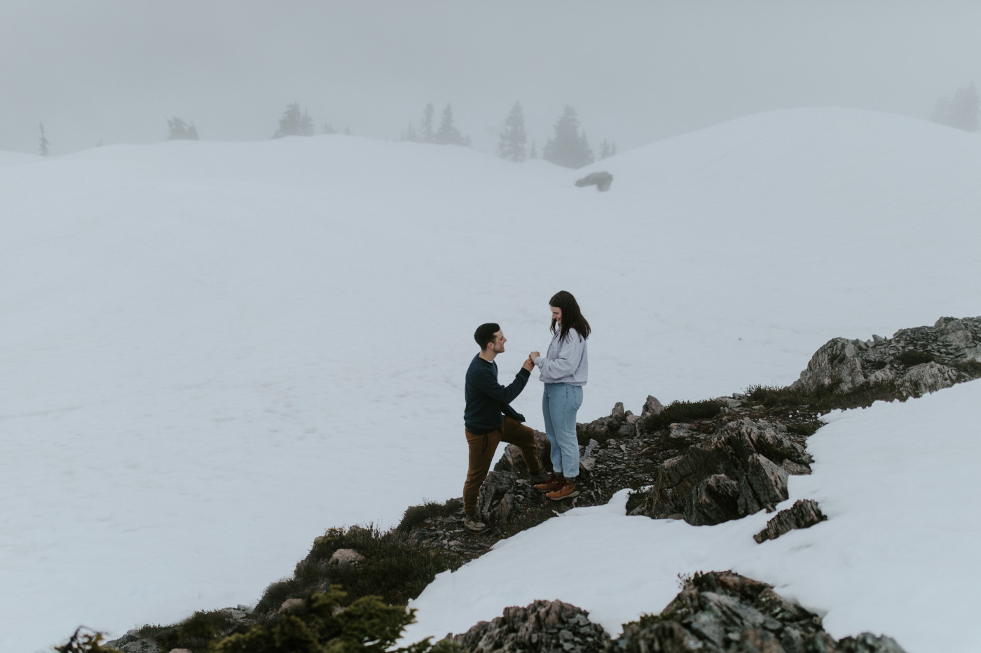 Kyle and Taylor stand in a snow flurry. Elopement photography at North Cascades National Park by Sienna Plus Josh.