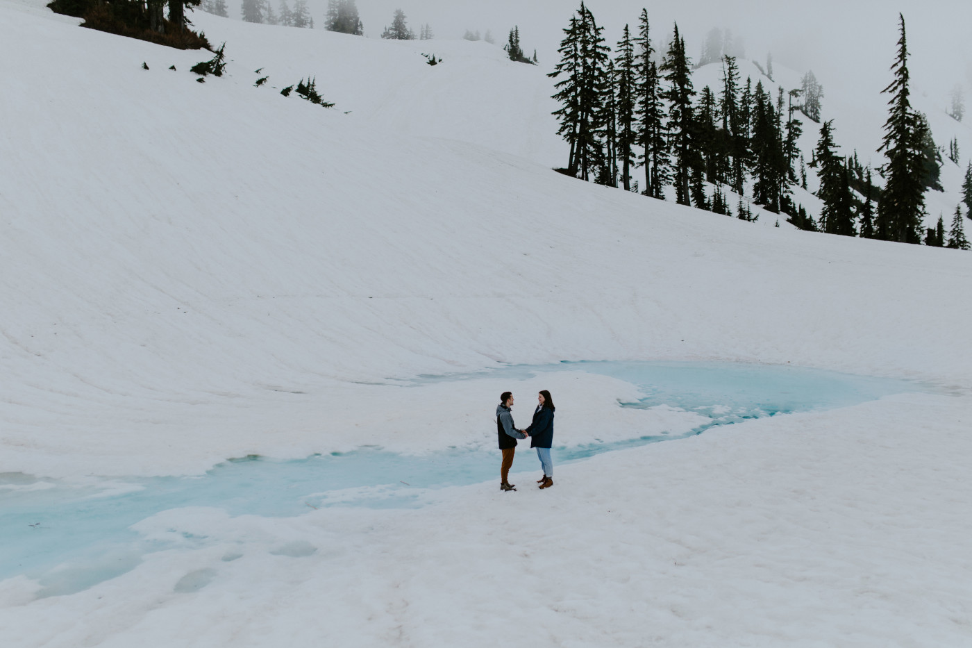 Kyle and Taylor stand hand in hand next to a very blue puddle. Elopement photography at North Cascades National Park by Sienna Plus Josh.