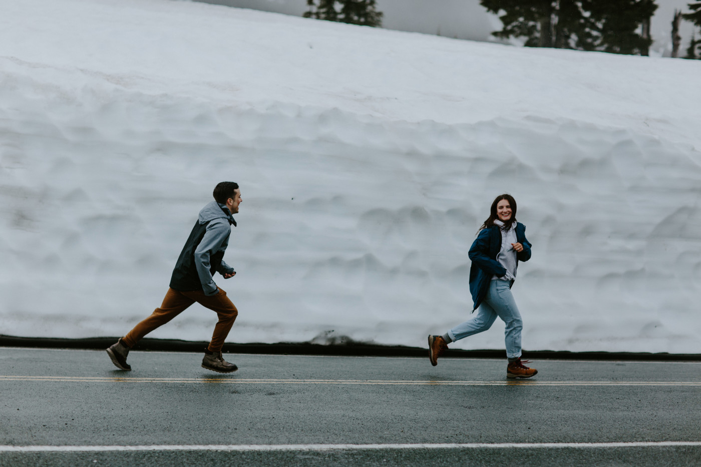 Taylor and Kyle play a game of tag on the road. Elopement photography at North Cascades National Park by Sienna Plus Josh.